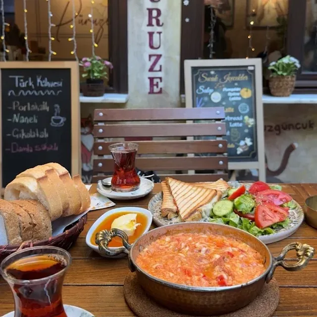 Serpme Kahvaltı — İcadiye Caddesi'nde masa, menemen, çay ve arkada Püruze tabelası
