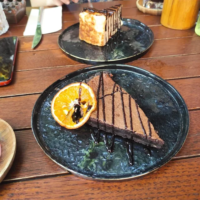Çikolatalı tart, kurutulmuş portakal ve arkada San Sebastian